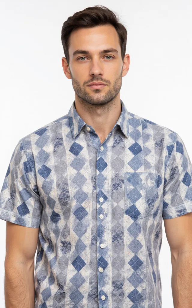 A French model wearing an Argyle pattern   printed shirt, against a white background, in a front   facing bust portrait